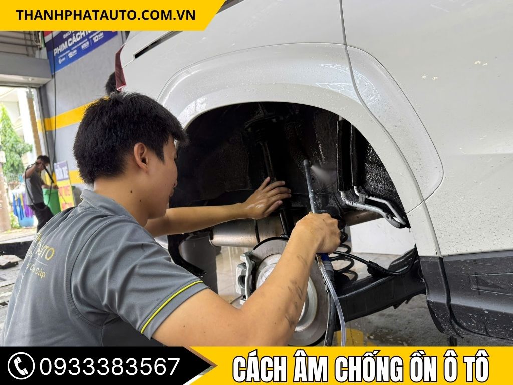 Kỹ thuật viên đang tiến hành thi công cách âm chống ồn cho xe, đặc biệt là khu vực gầm xe, giúp giảm tiếng ồn từ mặt đường và tiếng ồn từ bên ngoài. Quá trình này giúp cải thiện không gian yên tĩnh cho hành khách và người lái, tạo ra một trải nghiệm lái xe thoải mái và dễ chịu hơn.