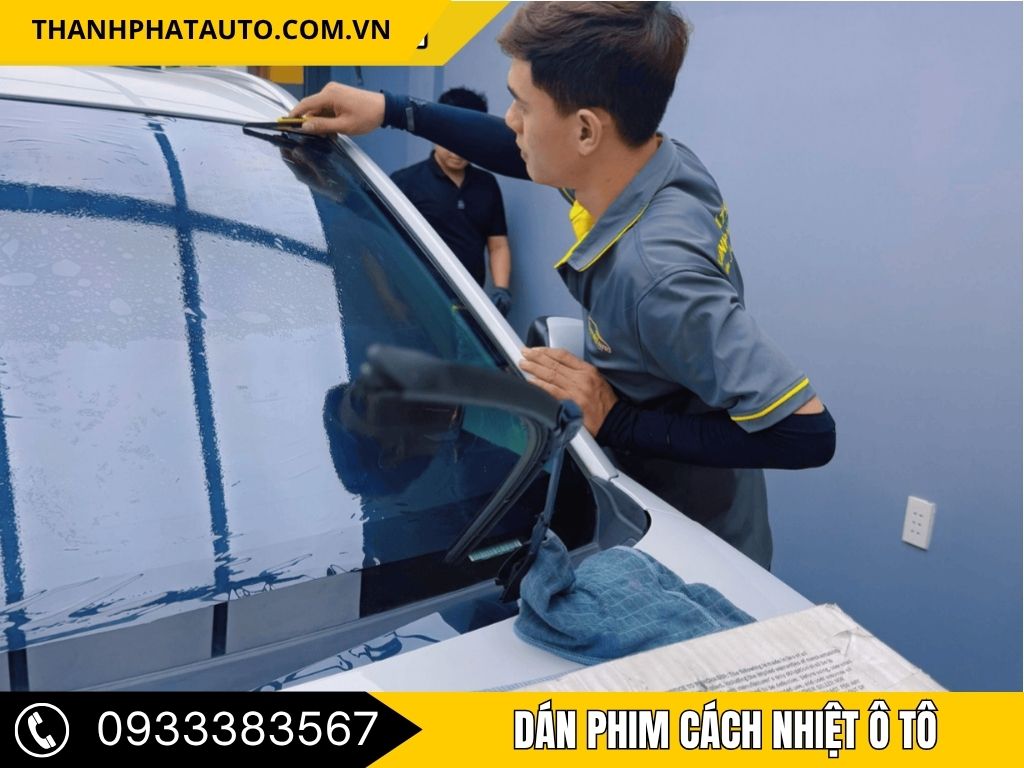 "Kỹ thuật viên đang thực hiện dán phim cách nhiệt ô tô tại Long Thành, giúp giữ cho không gian xe luôn mát mẻ và bảo vệ sức khỏe người ngồi."